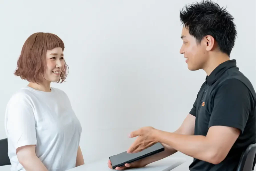 パーソナルジムでトレーナーが女性にカウンセリングを行っている様子